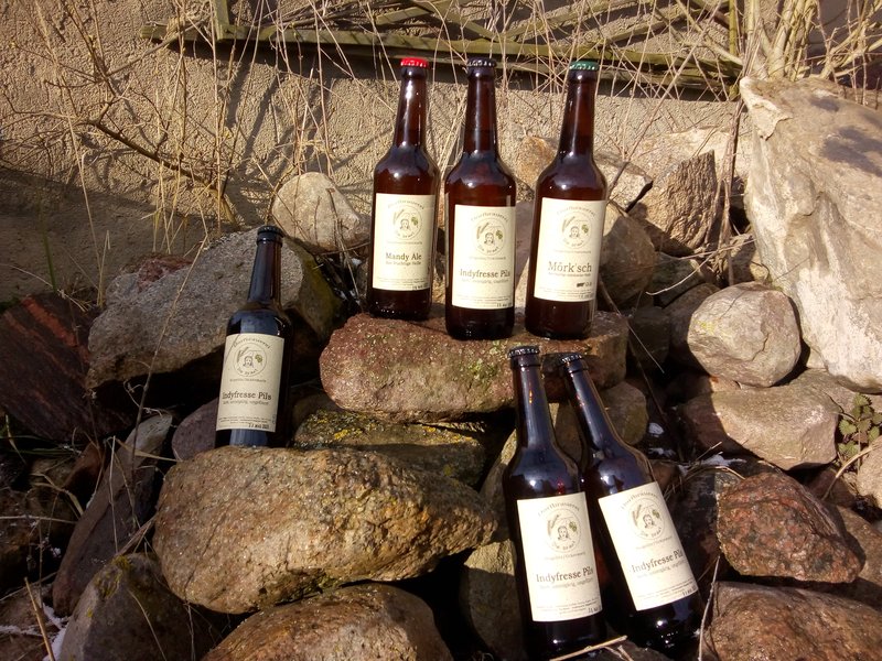 Bierflaschen von regional gebrautes Bier von Regionalwert-Partner Die braut auf einer Steinmauer platziert.